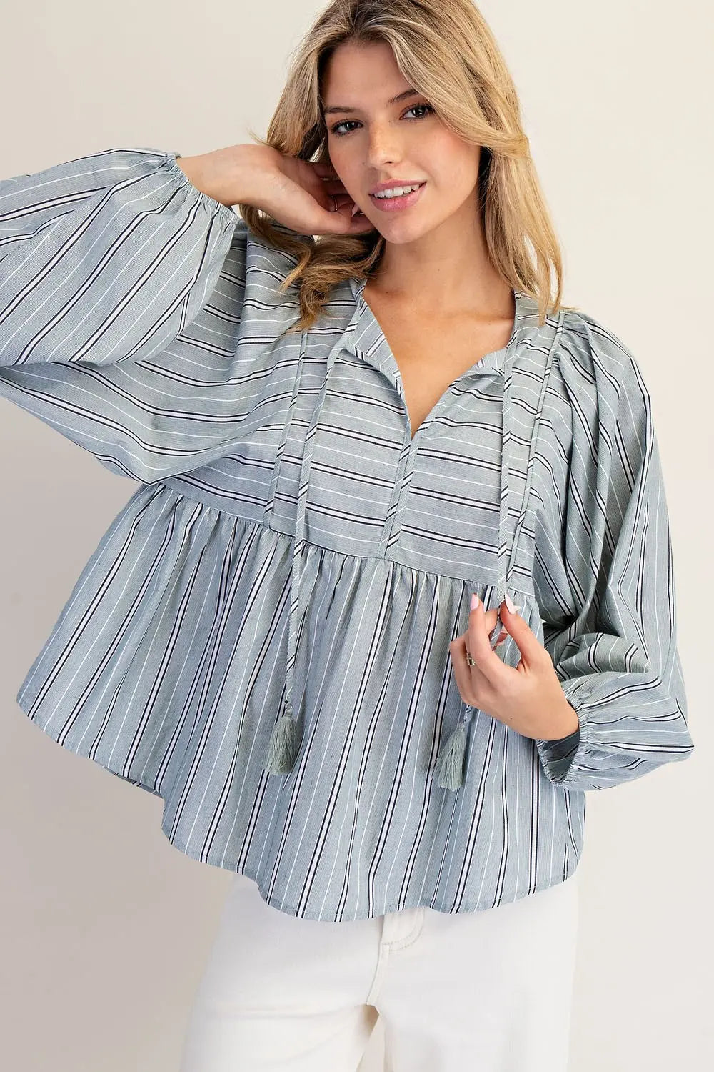 Woman wearing a blue striped blouse against a plain background