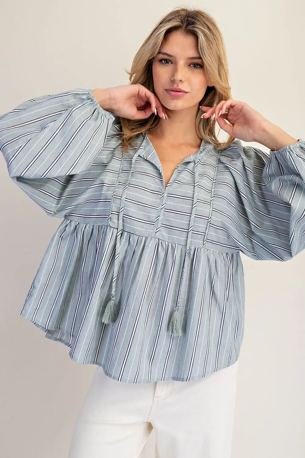 Woman wearing a blue striped blouse against a plain background